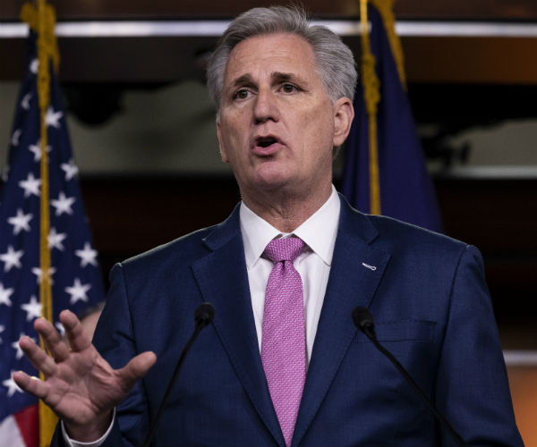 kevin mccarthy is shown with the american flag in the background